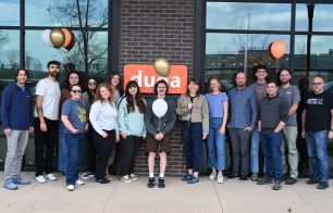 Team photo of Duda employees outside the office with balloons smiling