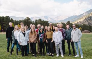 Team photo in field with mountain backdrop.